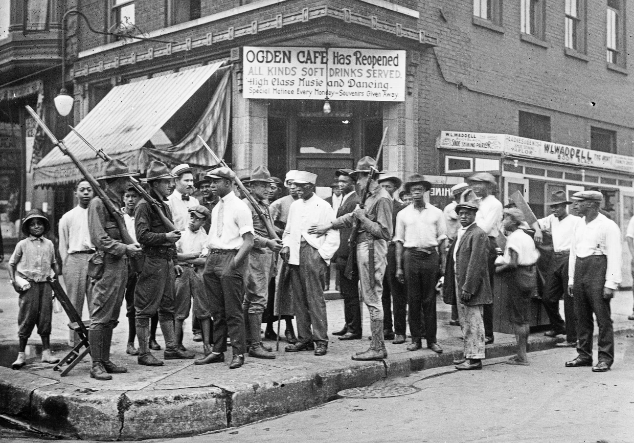 A victim is stoned and bludgeoned under a corner of a house during the race riots in Chicago in 1919.