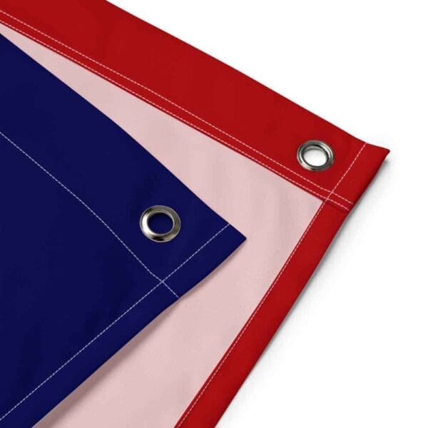 Close-up view of the sturdy iron grommet and reinforced stitching on the corner of the Juneteenth Flag Tapestry, highlighting its quality and durability for wall hanging.
